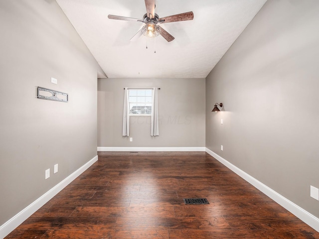 unfurnished room with ceiling fan, wood-type flooring, visible vents, and baseboards