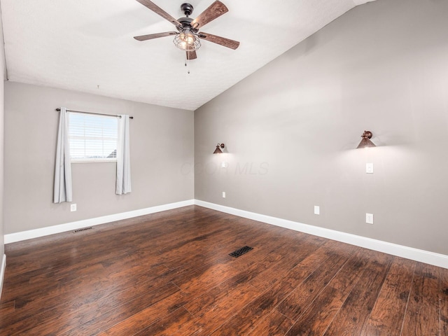 unfurnished room featuring visible vents, vaulted ceiling, and dark wood finished floors