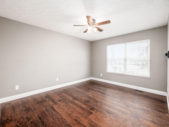 unfurnished room with dark wood-style floors, visible vents, ceiling fan, a textured ceiling, and baseboards