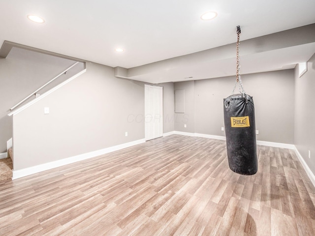 finished basement with light wood finished floors, stairway, recessed lighting, and baseboards