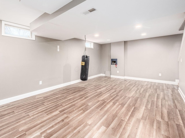 below grade area featuring a healthy amount of sunlight, light wood finished floors, baseboards, and visible vents