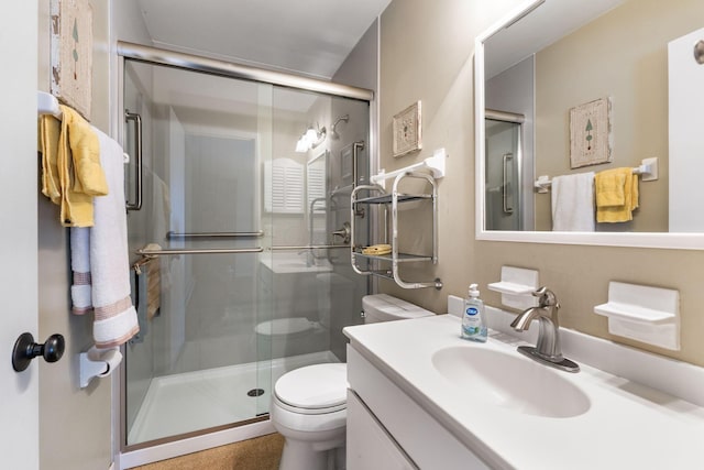 bathroom featuring toilet, vanity, and an enclosed shower