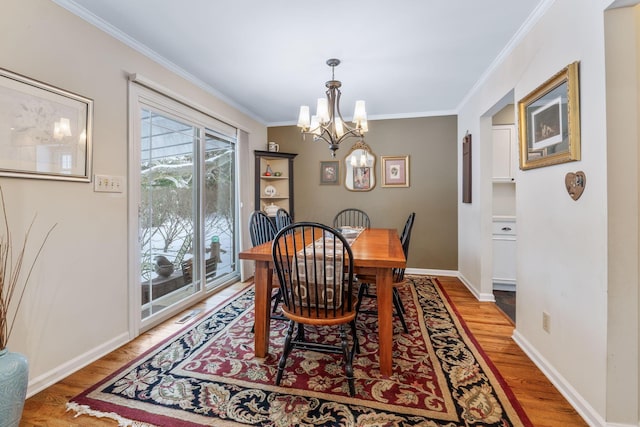 dining area featuring a chandelier, ornamental molding, and wood-type flooring