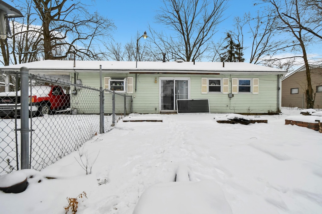 view of snow covered back of property