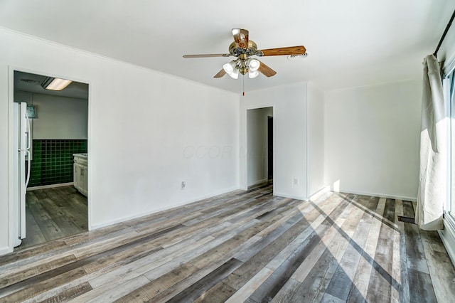 unfurnished room featuring ceiling fan, tile walls, and light hardwood / wood-style flooring