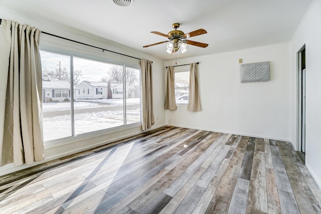 spare room with ornamental molding, ceiling fan with notable chandelier, and light hardwood / wood-style flooring