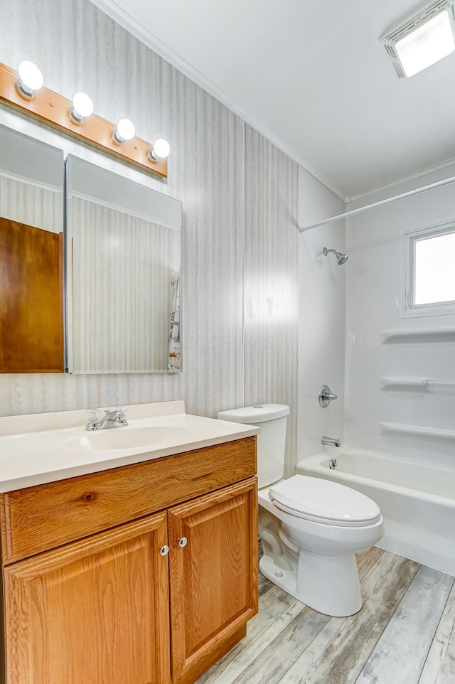 full bathroom featuring wood-type flooring, vanity, shower / bath combination, toilet, and ornamental molding