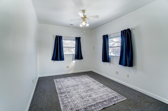 carpeted spare room with ceiling fan