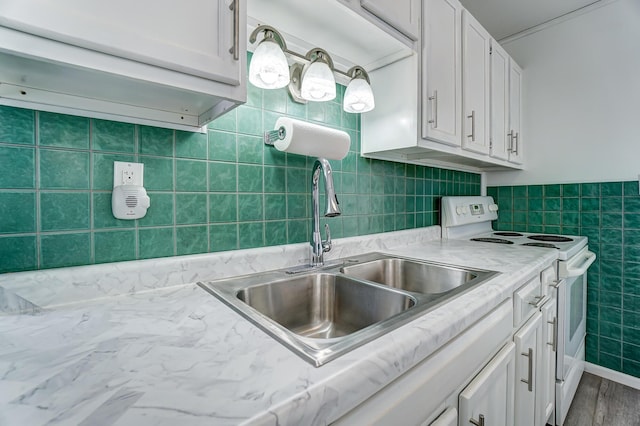 kitchen with tile walls, white electric range oven, sink, and white cabinetry