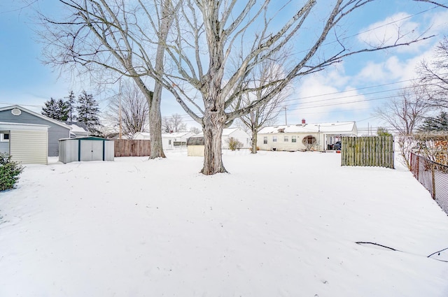 yard covered in snow with a storage unit