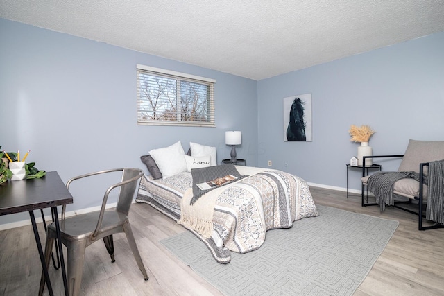 bedroom with a textured ceiling and hardwood / wood-style floors