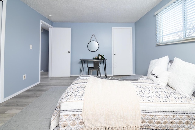 bedroom with a textured ceiling and hardwood / wood-style floors