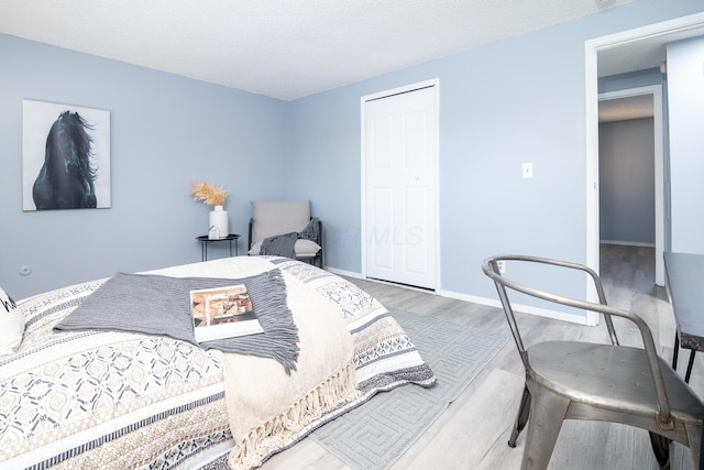 bedroom with wood-type flooring and a textured ceiling