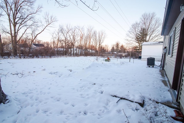 yard layered in snow featuring central air condition unit