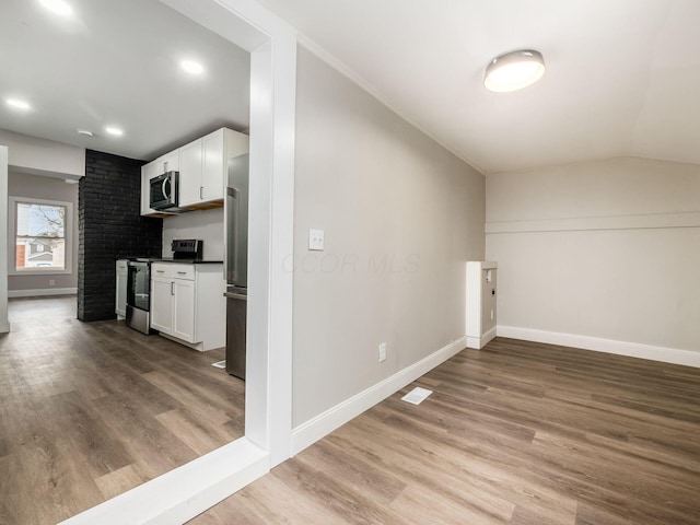 interior space with lofted ceiling and hardwood / wood-style floors