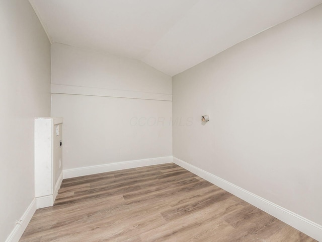 unfurnished room featuring lofted ceiling and wood-type flooring