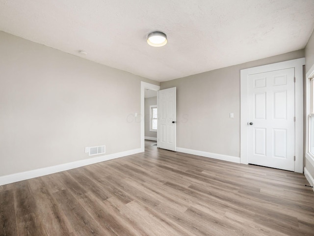 unfurnished bedroom with light hardwood / wood-style floors and a textured ceiling