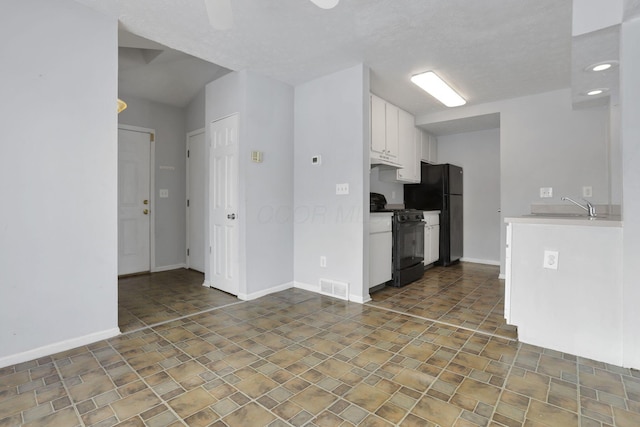 kitchen featuring sink, white cabinets, and black appliances