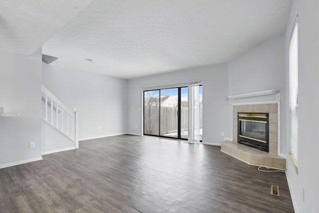 unfurnished living room featuring a textured ceiling, dark hardwood / wood-style flooring, and a fireplace