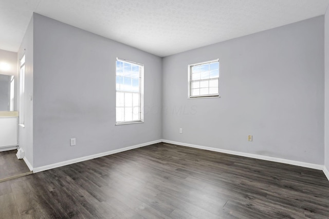 unfurnished room with a textured ceiling and dark hardwood / wood-style flooring