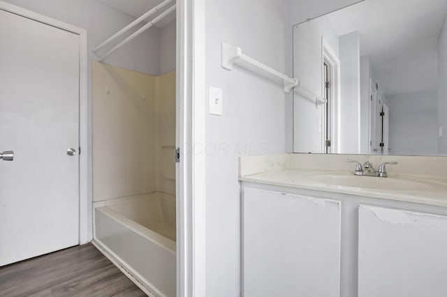 bathroom featuring hardwood / wood-style floors, vanity, and shower / bathing tub combination