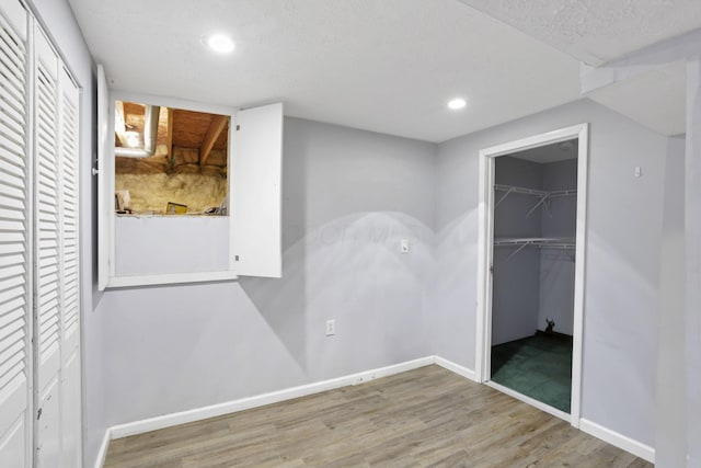 unfurnished bedroom with hardwood / wood-style floors and a textured ceiling