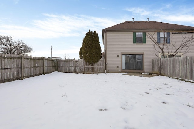 view of snow covered rear of property