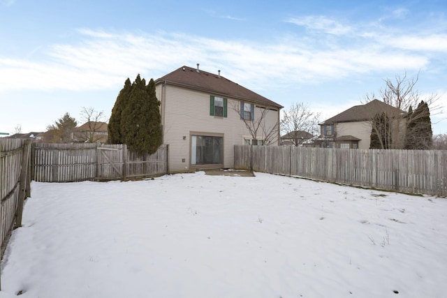 view of snow covered rear of property