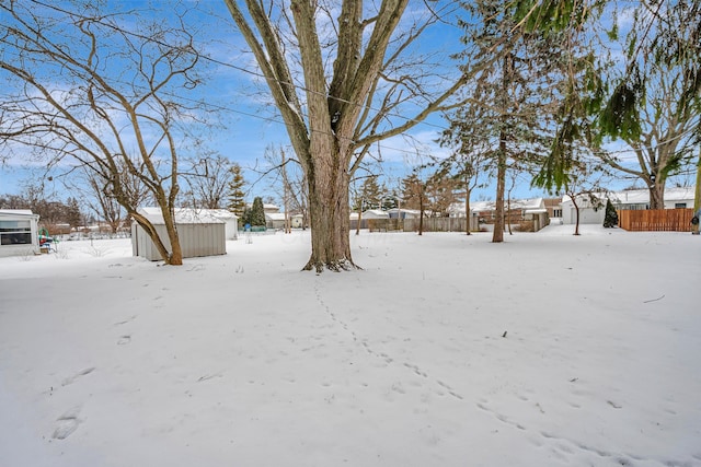 yard covered in snow featuring a storage unit