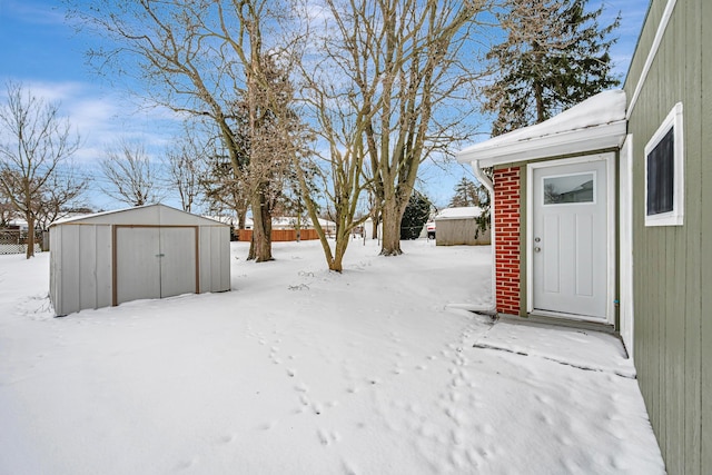 yard layered in snow with a shed