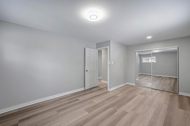 unfurnished bedroom with a closet and light hardwood / wood-style flooring