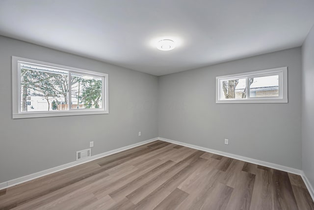 unfurnished room featuring light hardwood / wood-style floors and plenty of natural light