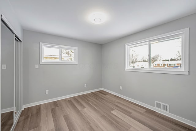 unfurnished bedroom with a closet and light wood-type flooring