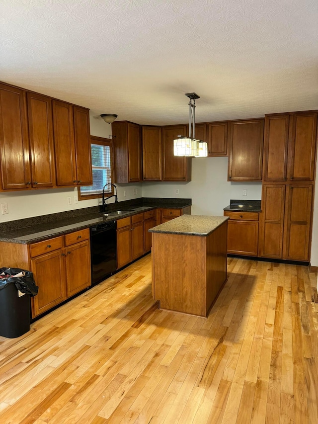 kitchen with light wood-type flooring, black dishwasher, pendant lighting, and a center island