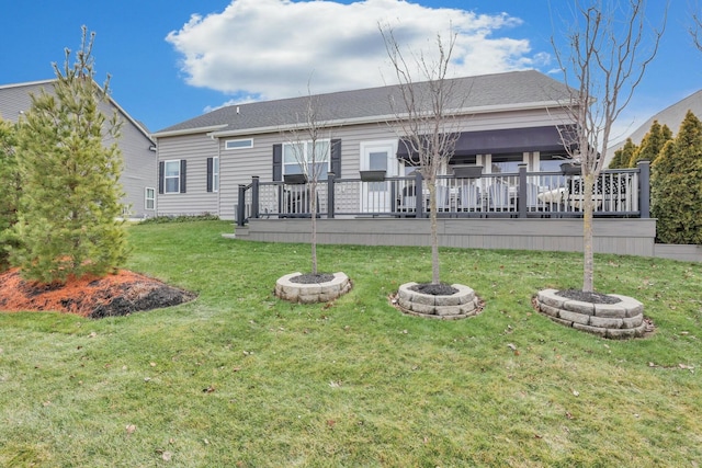 back of house featuring a wooden deck, a yard, and a fire pit