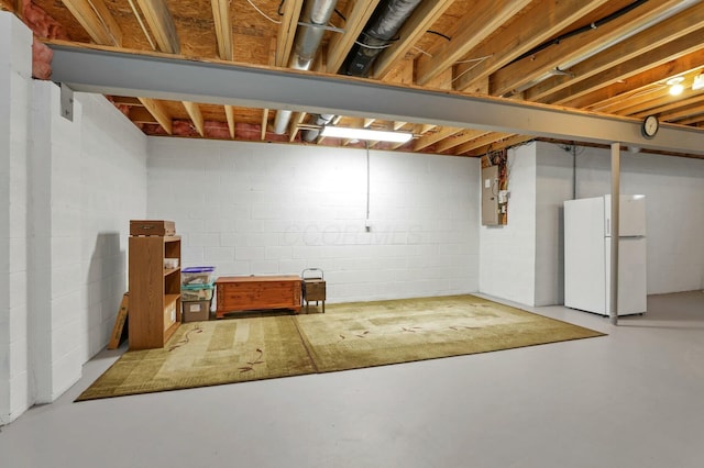 basement with electric panel and white fridge