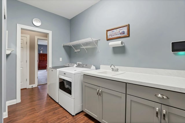 clothes washing area with sink, dark hardwood / wood-style floors, cabinets, and independent washer and dryer