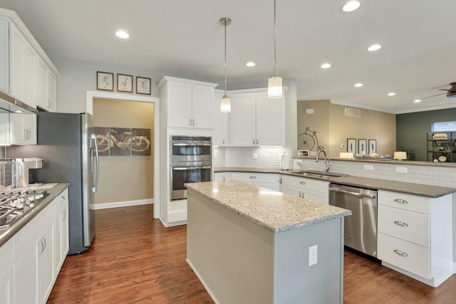 kitchen with a kitchen island, appliances with stainless steel finishes, sink, and kitchen peninsula