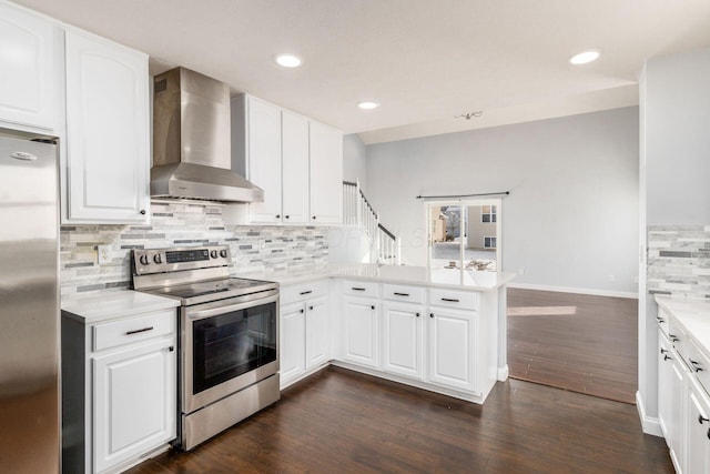 kitchen featuring white cabinetry, wall chimney range hood, stainless steel appliances, and kitchen peninsula