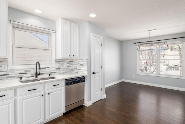 kitchen with pendant lighting, sink, backsplash, white cabinets, and stainless steel dishwasher