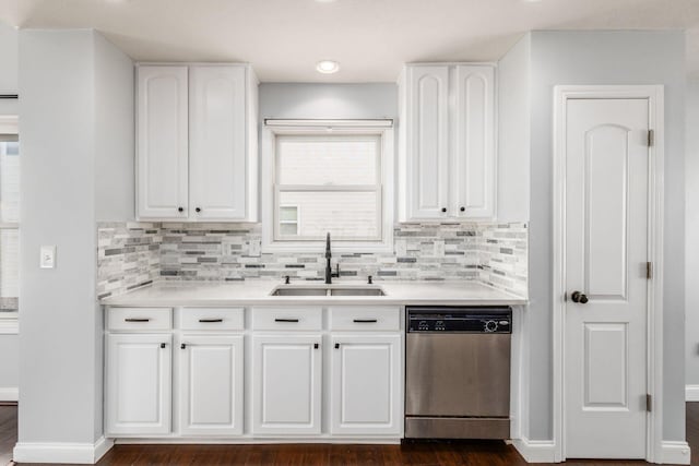 kitchen featuring tasteful backsplash, dishwasher, sink, and white cabinets