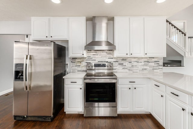 kitchen with wall chimney exhaust hood, white cabinetry, and stainless steel appliances