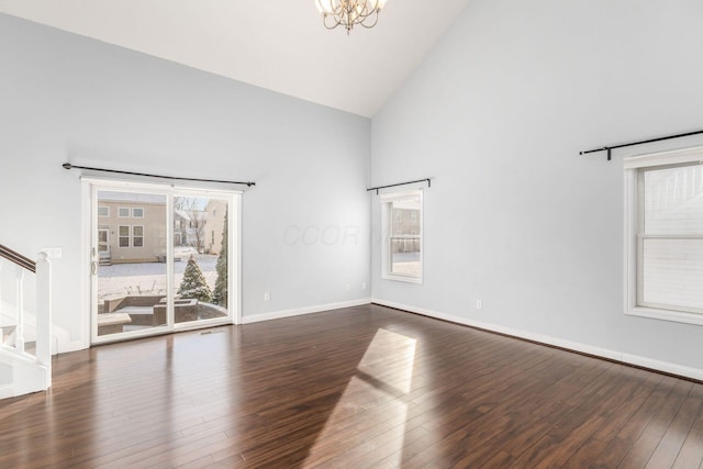 spare room featuring an inviting chandelier, dark hardwood / wood-style flooring, and high vaulted ceiling