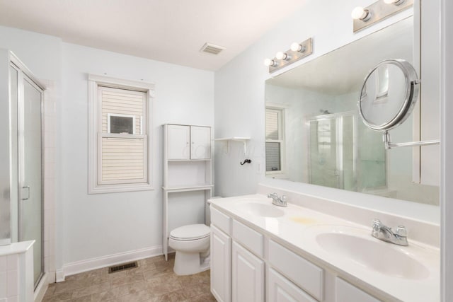 bathroom featuring vanity, toilet, and a shower with shower door