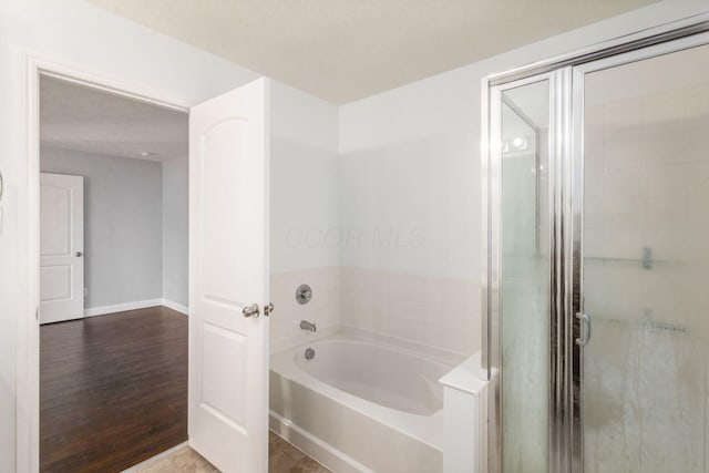 bathroom with tile patterned floors, plus walk in shower, and a textured ceiling