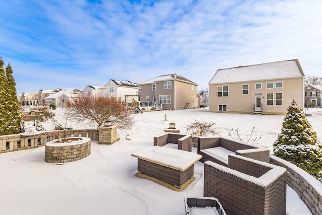 snow covered patio with an outdoor fire pit