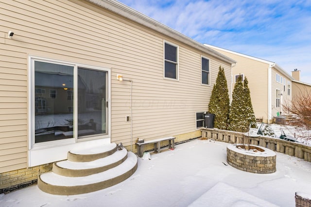 snow covered property featuring an outdoor fire pit