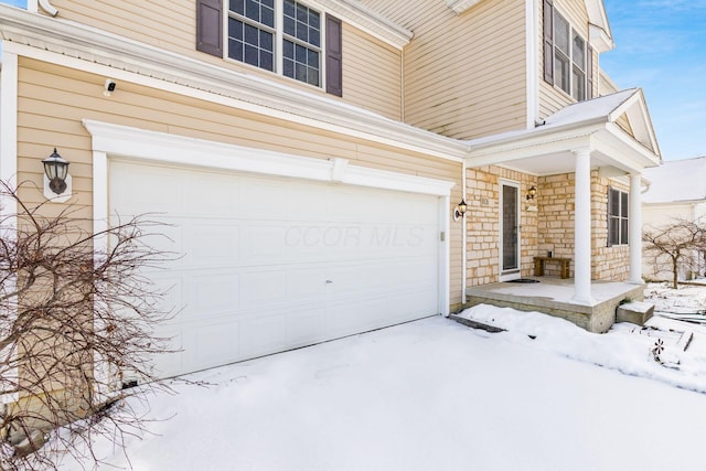 snow covered property featuring a garage