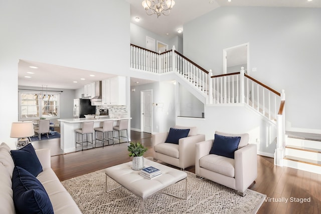 living room featuring dark hardwood / wood-style flooring, a notable chandelier, and high vaulted ceiling