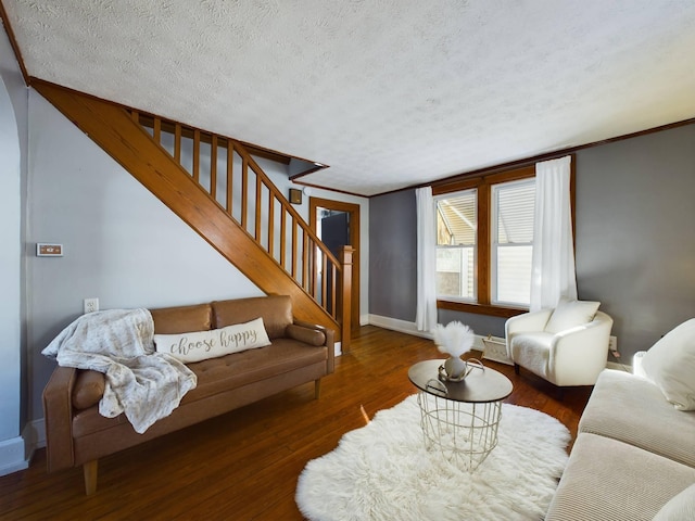 living room featuring a textured ceiling, dark hardwood / wood-style flooring, and ornamental molding